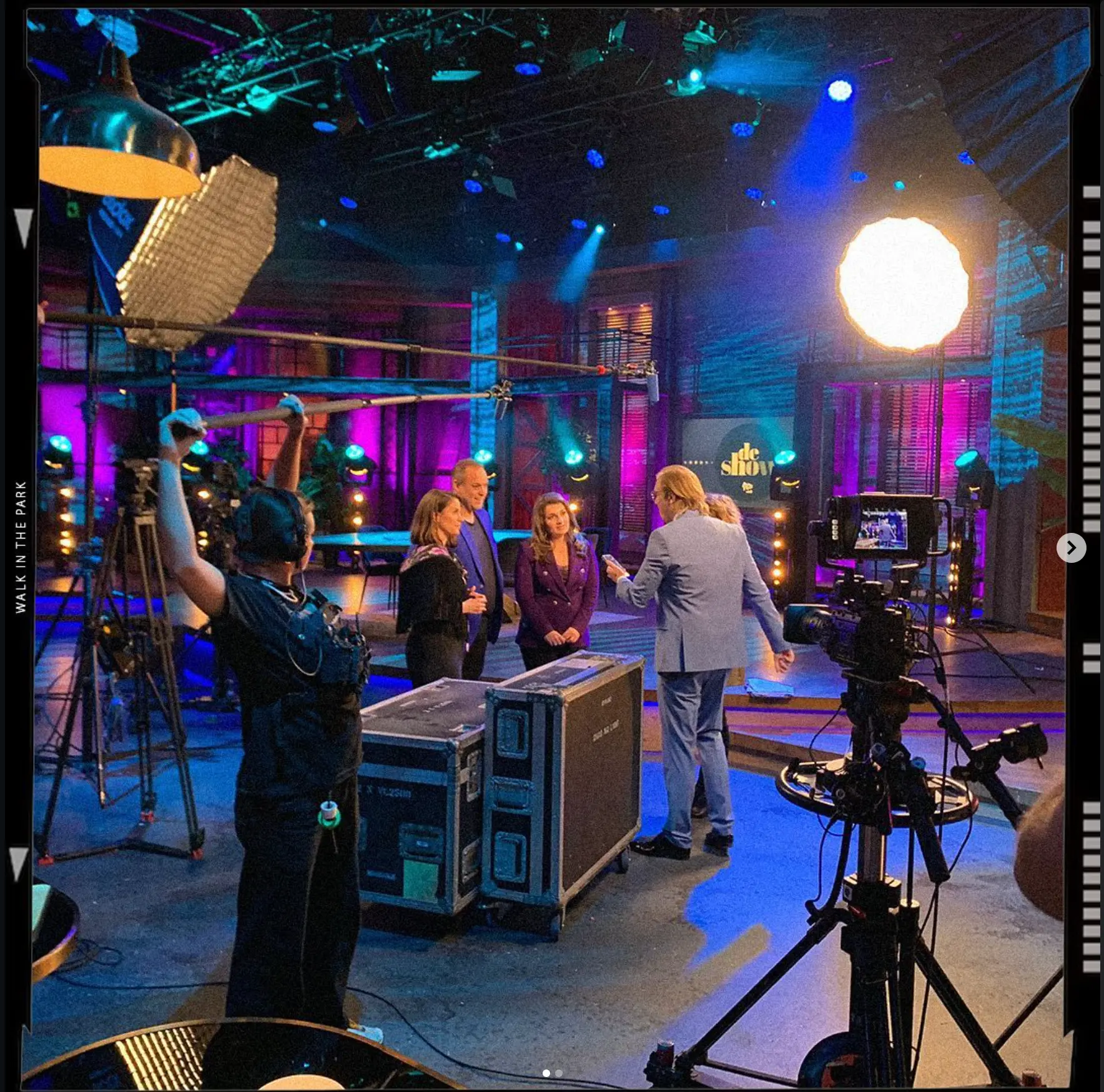Boom operator and camera crew on a colourful talkshow set